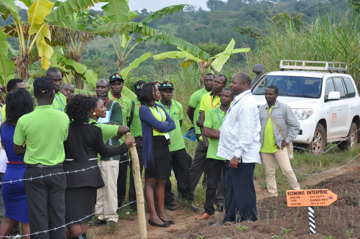 IITA DG speaking to one of the Uganda youth Agripreneurs during a field visit to see some of the farming activities they are already engaged in.