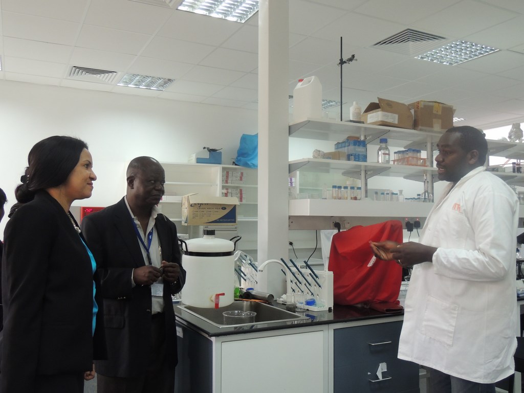 Dr Tausi Kida listens to Mr Harun Murithi’s (right) explanation about research on soybean rust. She is accompanied by Dr Victor Manyong (center).