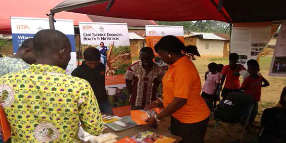 Cassava Breeder Elizabeth Parkes attending to farmers and guests at the IITA stand.