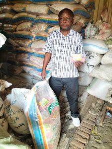 Herman Mutabataba, founder and director of Agriforce Seed Company, pictured here with small packs of hybrid maize procured from neighboring Uganda (Naseco Seed Company), facilitated by an AID-I GLR service provider partner, Seed Systems Group (SSG)