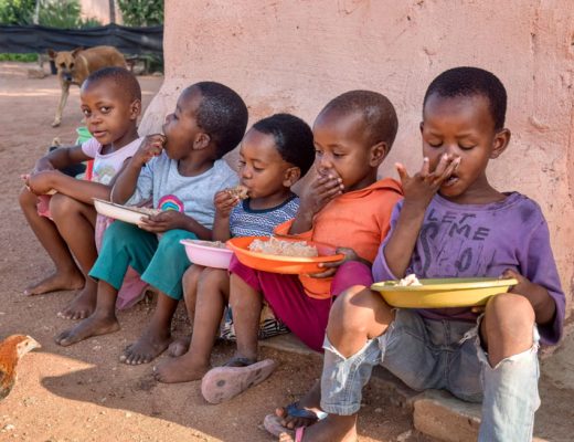 african kids eating some sorghum porridge, village in botswana