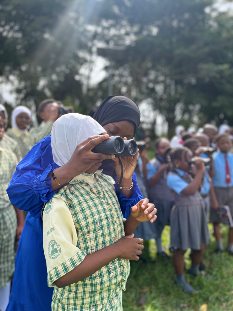 Getting a closer look: A student is assisted with using binoculars during the birdwatching session at the IITA Forest Centre. Photo: Ogheneovie Kome
